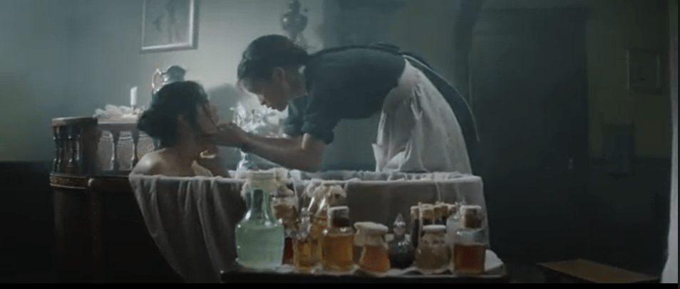 Hideko está nua em uma banheira, enquanto Sook-Hee raspa seu dente. O cenário em torno é luxuoso, com produtos de banho à mostra