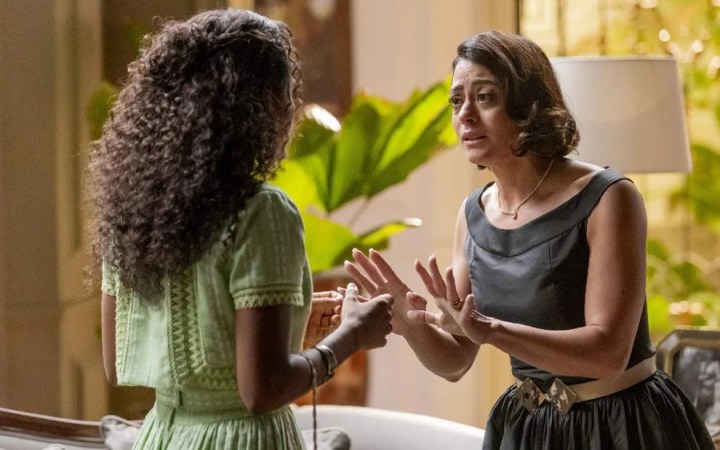 Cena dramática entre duas mulheres, uma de frente e a outra de costas, em um ambiente interno, discutindo com expressões emocionais intensas, simbolizando conflitos pessoais entre amizades ou familiares.